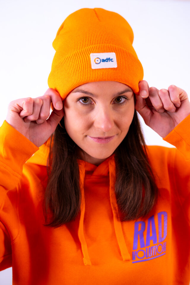 Frau hat orangene Mütze mit adfc Logo auf